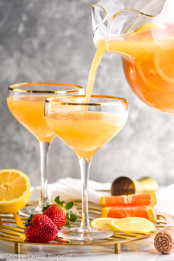 two glasses mimosa sangria recipe ingredients with orange slices and strawberries