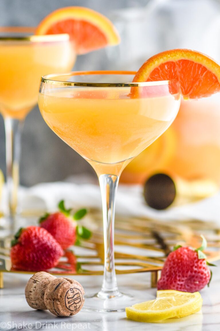 Two glasses mimosa sangria recipe with orange wedges and strawberries