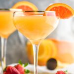 two glasses mimosa sangria with orange slices and strawberries