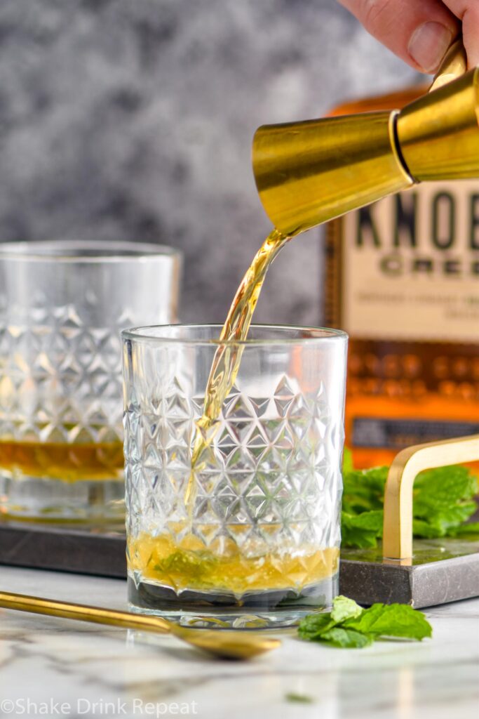 making a mint julep recipe with bourbon and mint leaves