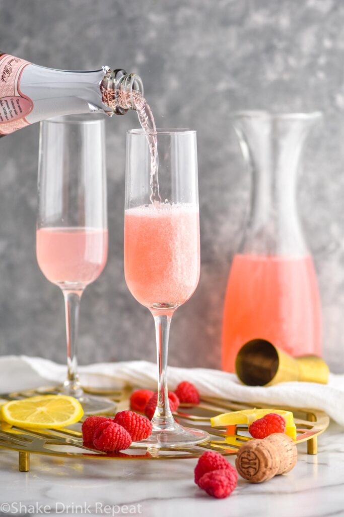 champagne flutes with pink mimosa ingredients and rose