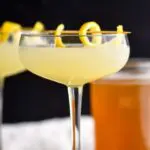 glass of bees knees cocktail with lemon and honey syrup