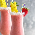 Bunny Colada in a glass with strawberries, coconut and peeps garnishing it with a straw