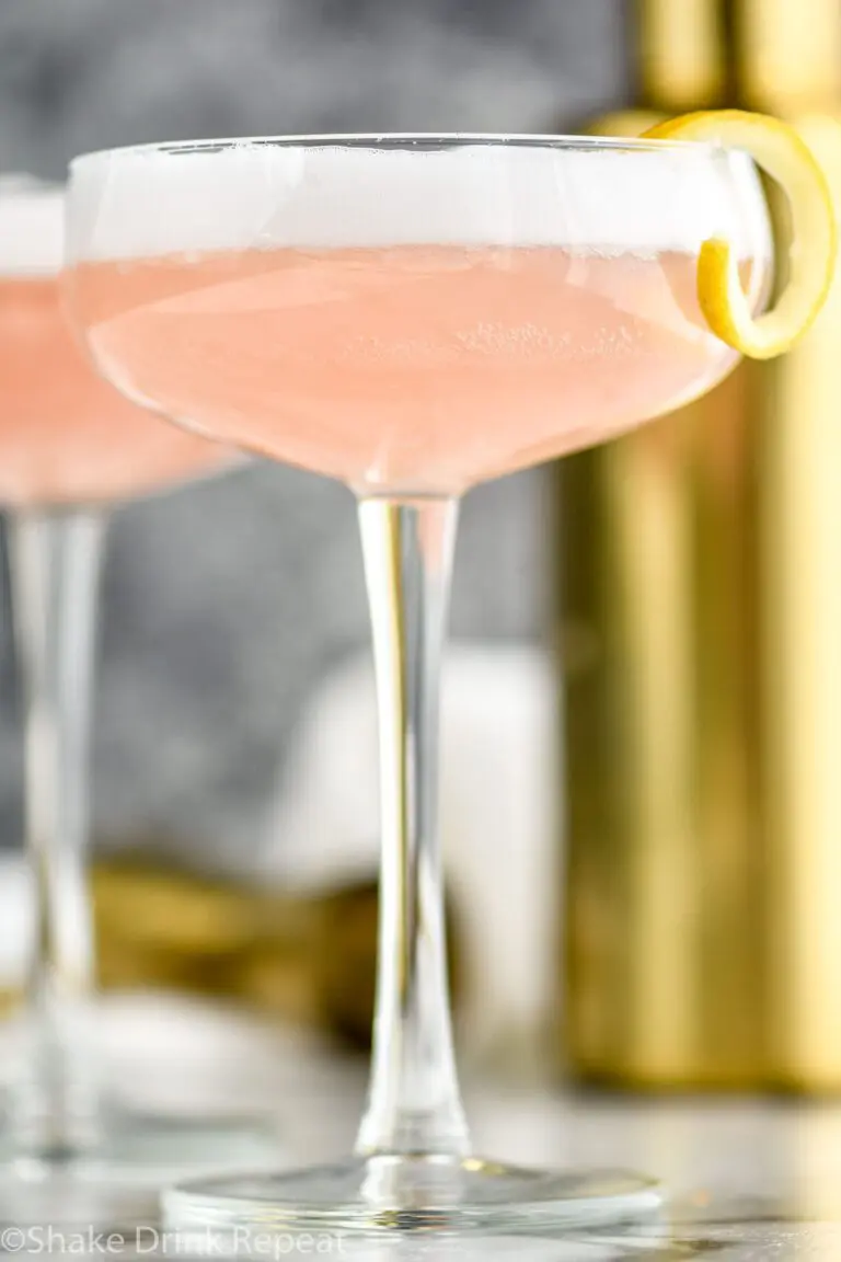 glass of cranberry gin fizz with lemon twist