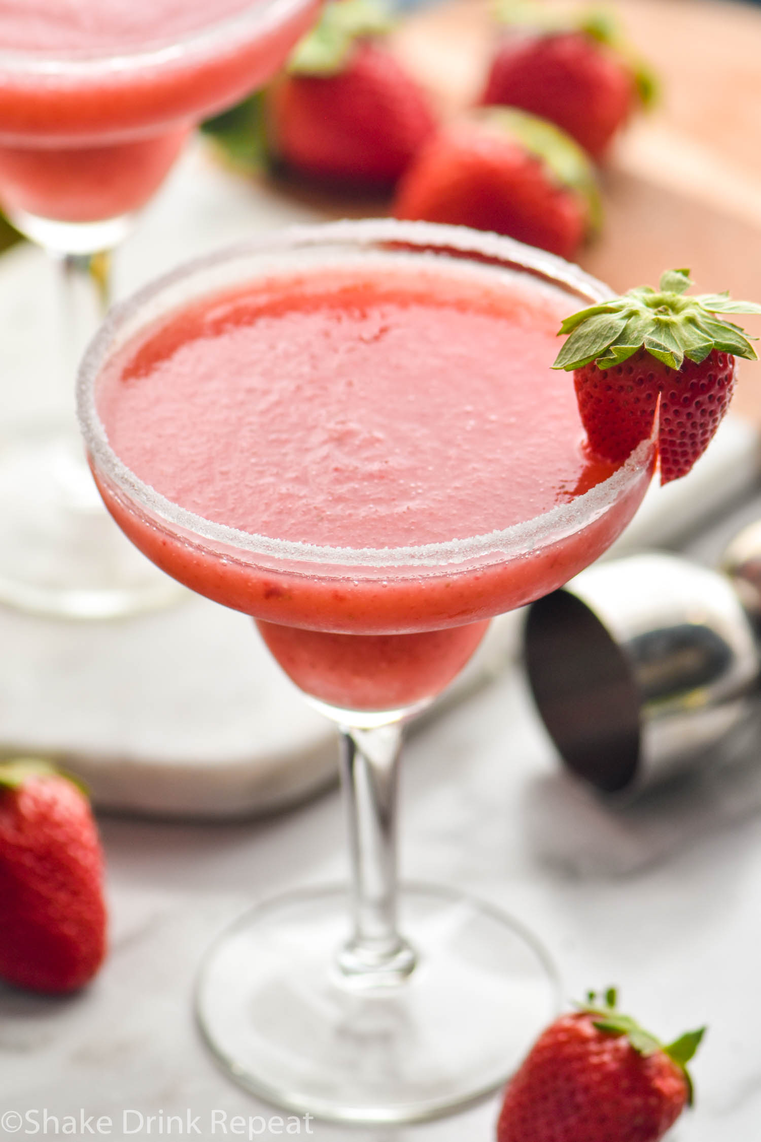 glass of frozen strawberry margarita with sugared rim and fresh strawberry garnish