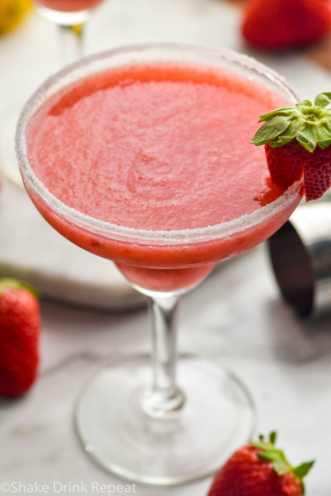 glass of frozen strawberry margarita with sugared rim and fresh strawberry garnish