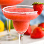 glass of frozen strawberry margarita with sugared rim and fresh strawberry garnish