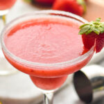 glass of frozen margarita with sugared rim and fresh strawberry garnish