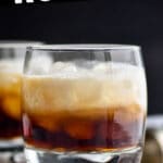 two glasses of white russian cocktail with ice and surrounded by coffee beans