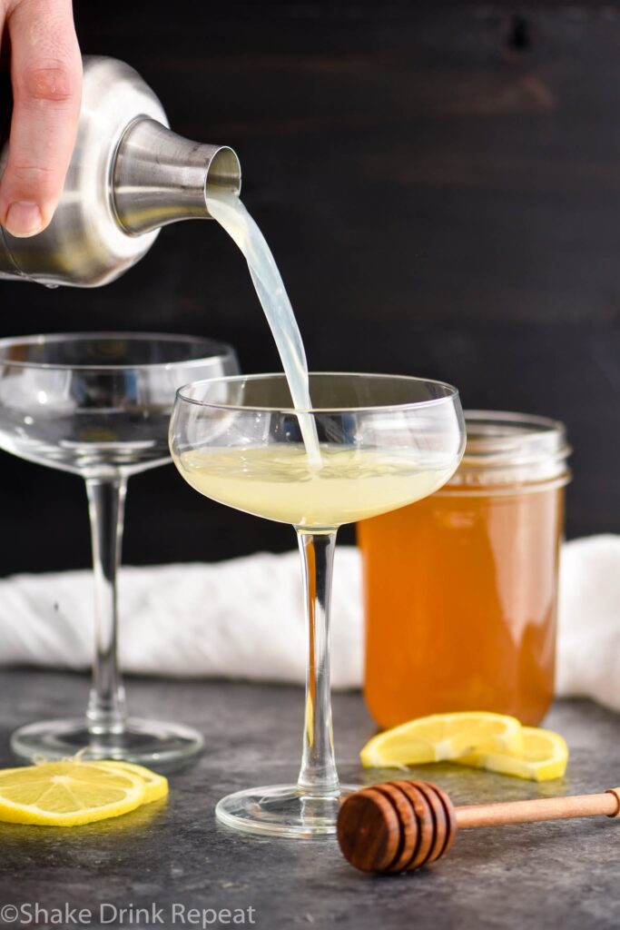 making glass of bees knees cocktail recipe with honey syrup and lemon
