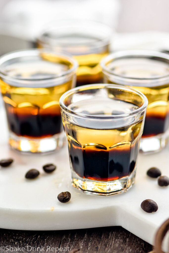 glasses of layered mind eraser shot surrounded by coffee beans