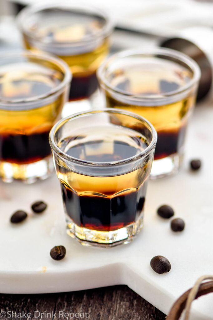 glasses of layered mind eraser shot surrounded by coffee beans