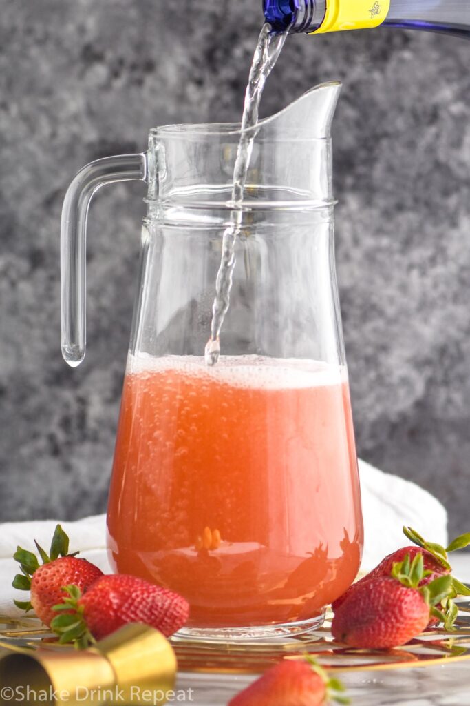 pitcher of strawberry margarita sangria with white wine poured in