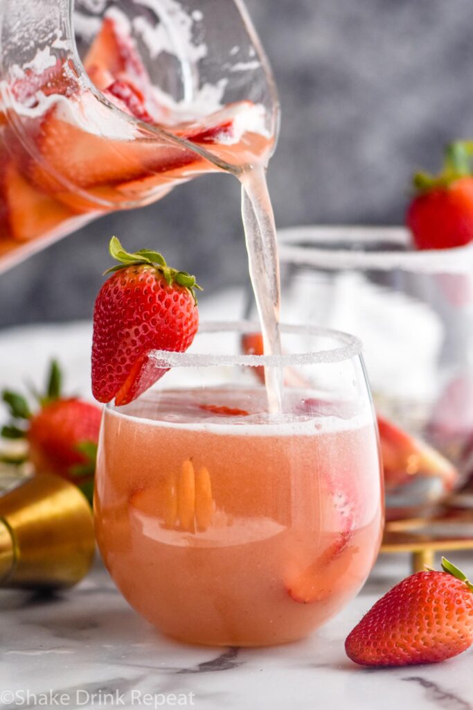 glass of strawberry margarita sangria with sugar coated rim and strawberry garnish