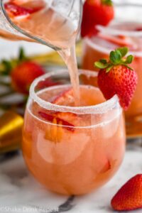 glass of Strawberry Margarita Sangria with sugar coated rim and garnish