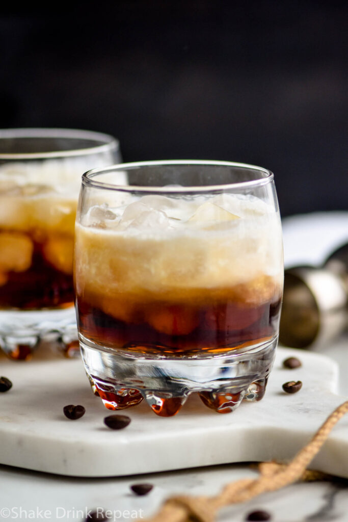 two glasses of white russian cocktail with ice and coffee beans