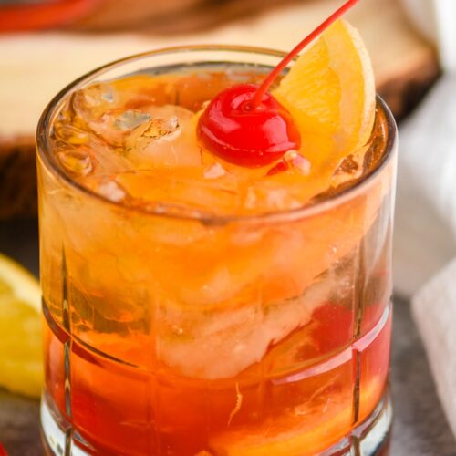 glass of wisconsin brandy old fashioned with ice, brandy, cherry, and orange