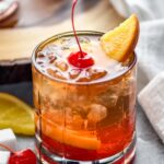 glass of wisconsin old fashioned with ice, cherry, and orange