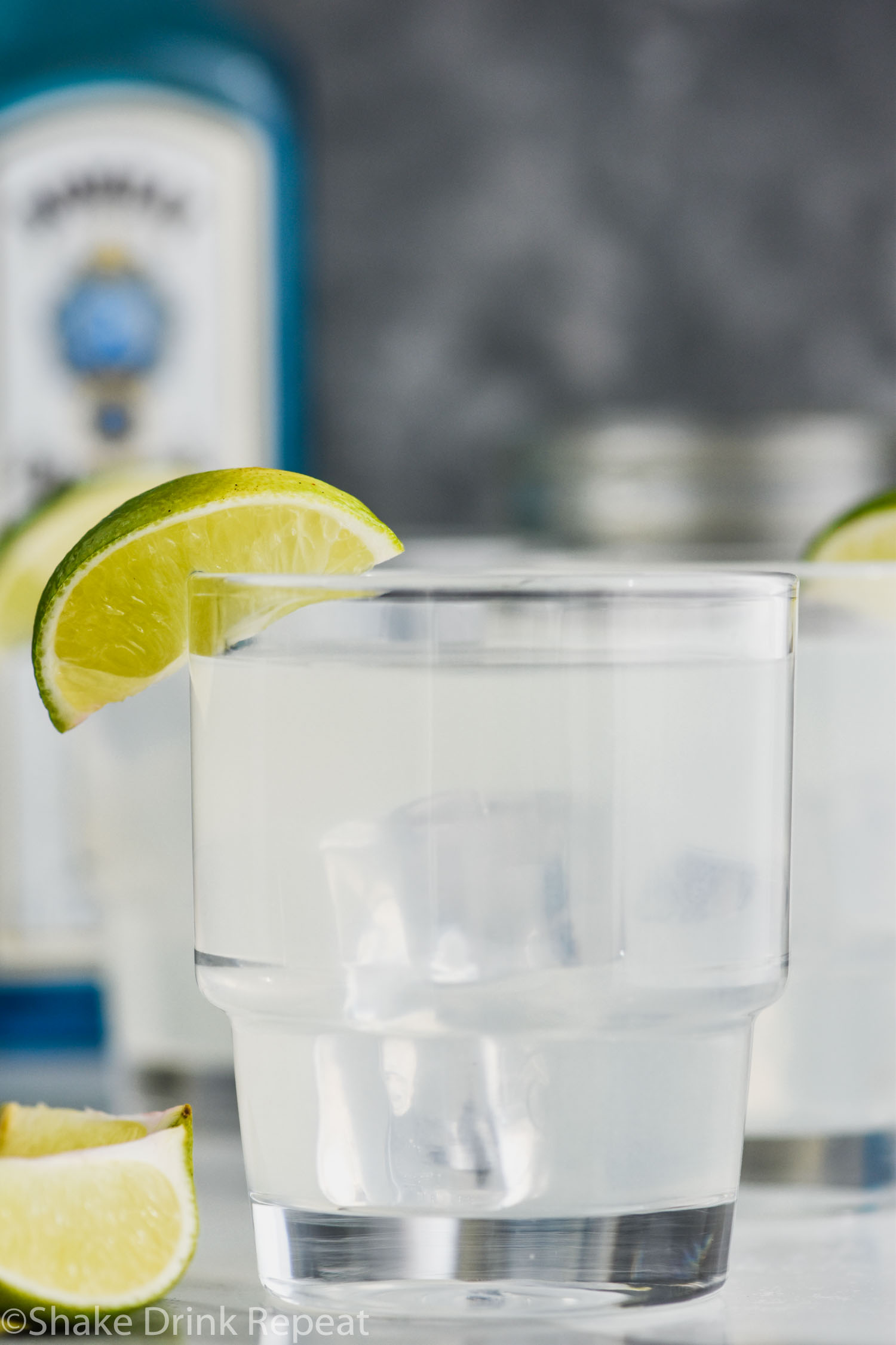 glass of gin gimlet with ice and lime