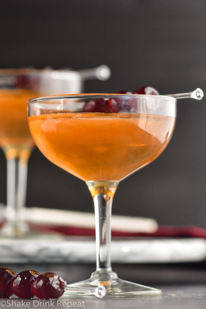 glass of Manhattan cocktail with cherries to garnish