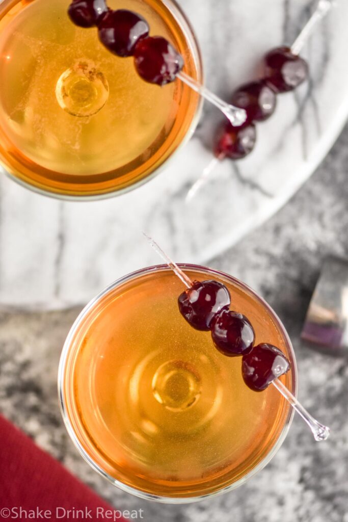 two glasses of Manhattan cocktails with cherries to garnish