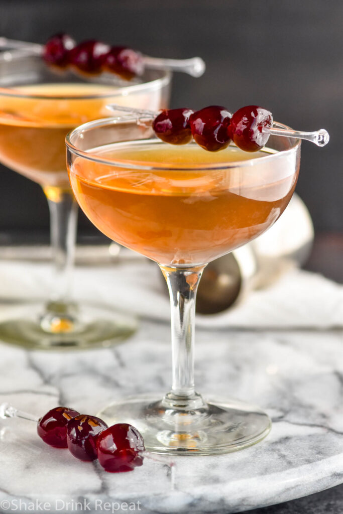 two glasses of Manhattan cocktails with cherry garnish