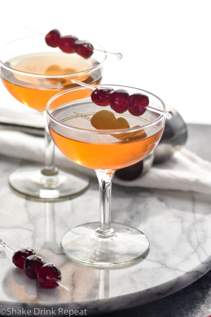 Two glasses of Manhattan cocktails with cherry garnish
