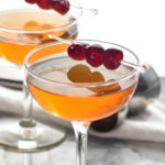 two glasses of Manhattan with cherry garnish