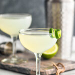 two cocktail glasses of daiquiri with lime twist