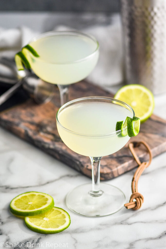 two glasses of daiquiri surrounded by lime slices