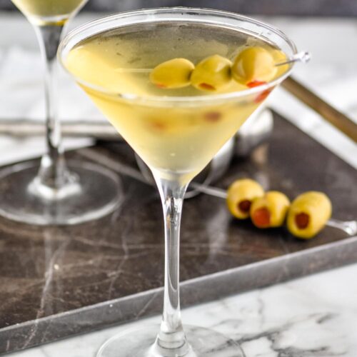 two glasses of dirty martini with green olives