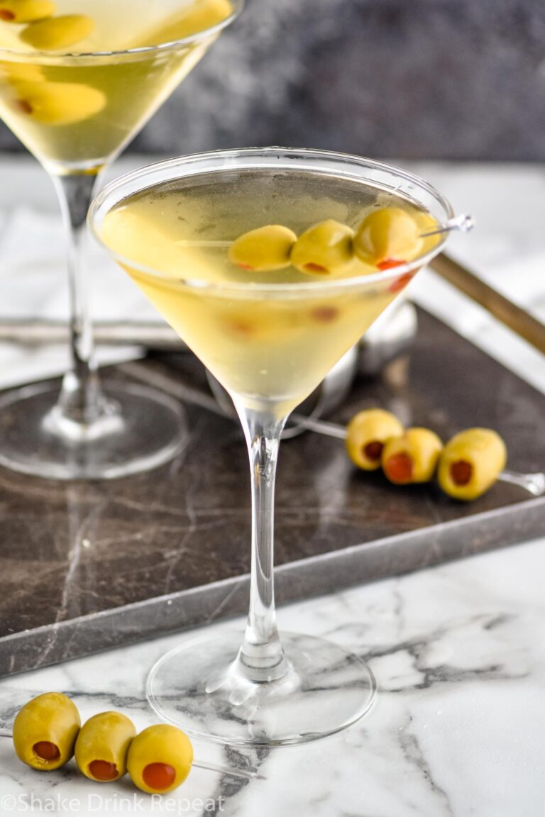 two glasses of dirty martini with green olives