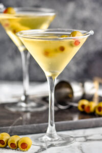 two glasses of dirty martini with green olives
