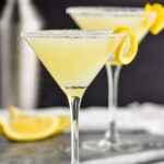 two glasses of lemon drop martini with sugared rim and lemon twist