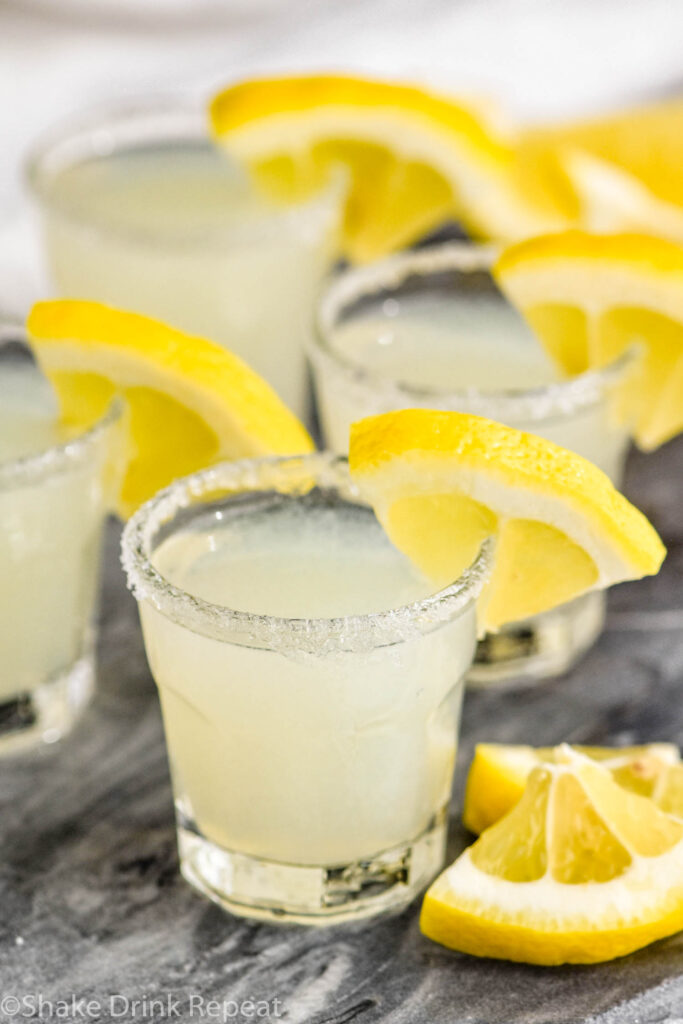 shot glasses of lemon drop shot recipe with sugared rim and lemon wedge