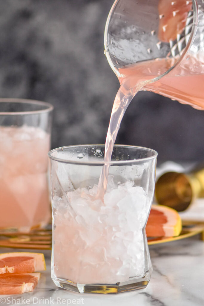 making a glass of Paloma cocktail with crushed ice and grapefruit