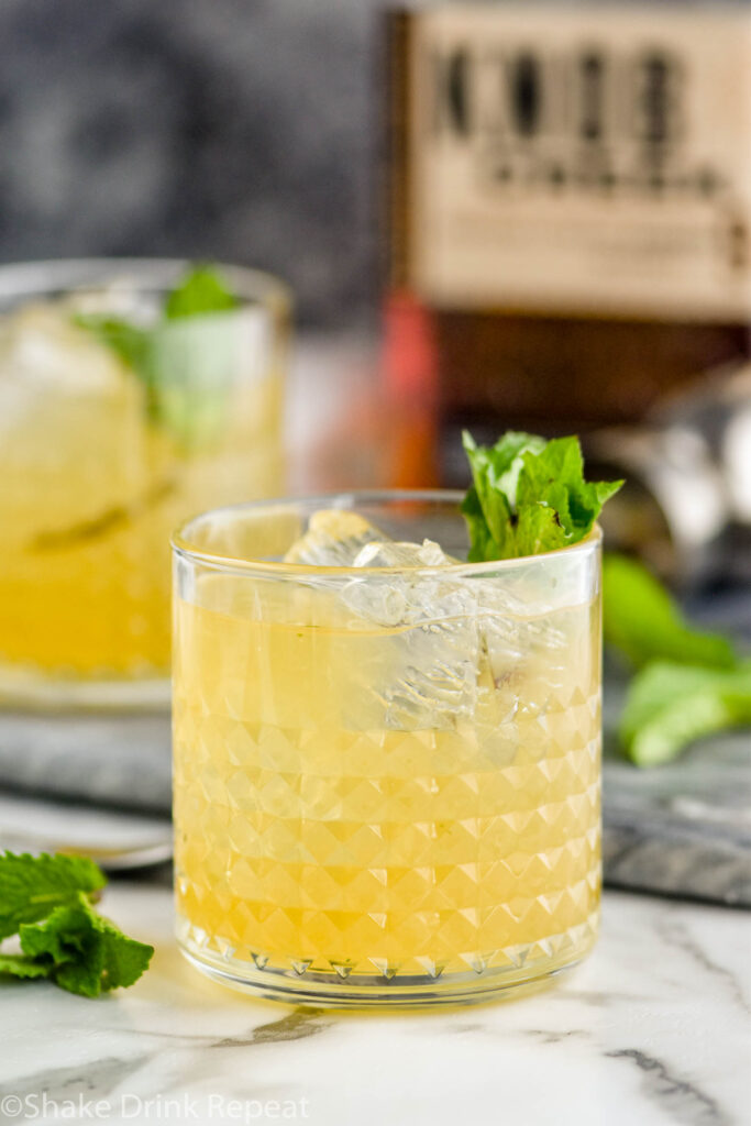 two glasses of whiskey smash with ice, mint, lemon and whiskey