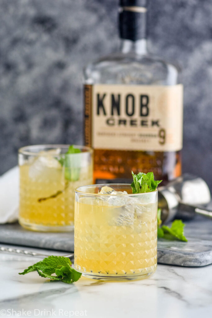 two glasses of whiskey smash with ice, mint, lemon, and whiskey
