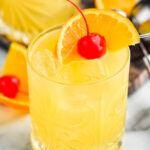 glass of Amaretto Stone Sour with ice, orange slice, and cherry garnish