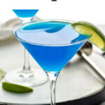 martini glass of blue daiquiri with fresh lime wedge