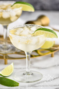 two glasses of Cadillac Margarita with ice, salted rim and lime wedge garnish
