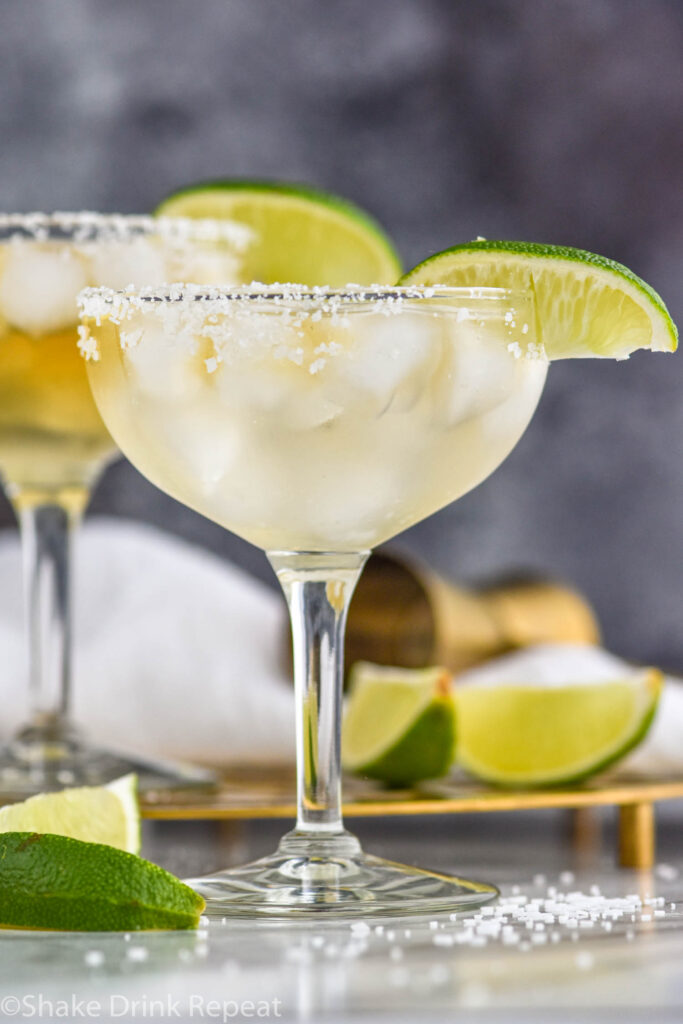 two glasses of Cadillac Margarita with salted rim, ice, and lime wedge garnish