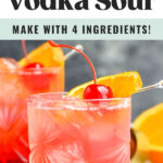 two glasses of cherry vodka sour with ice, orange slice and cherry garnish