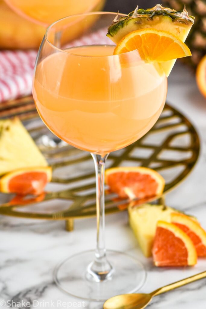 glass of tropical sangria with slices of fresh pineapple and oranges