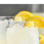 two glasses of vodka lemonade with ice and lemon slices