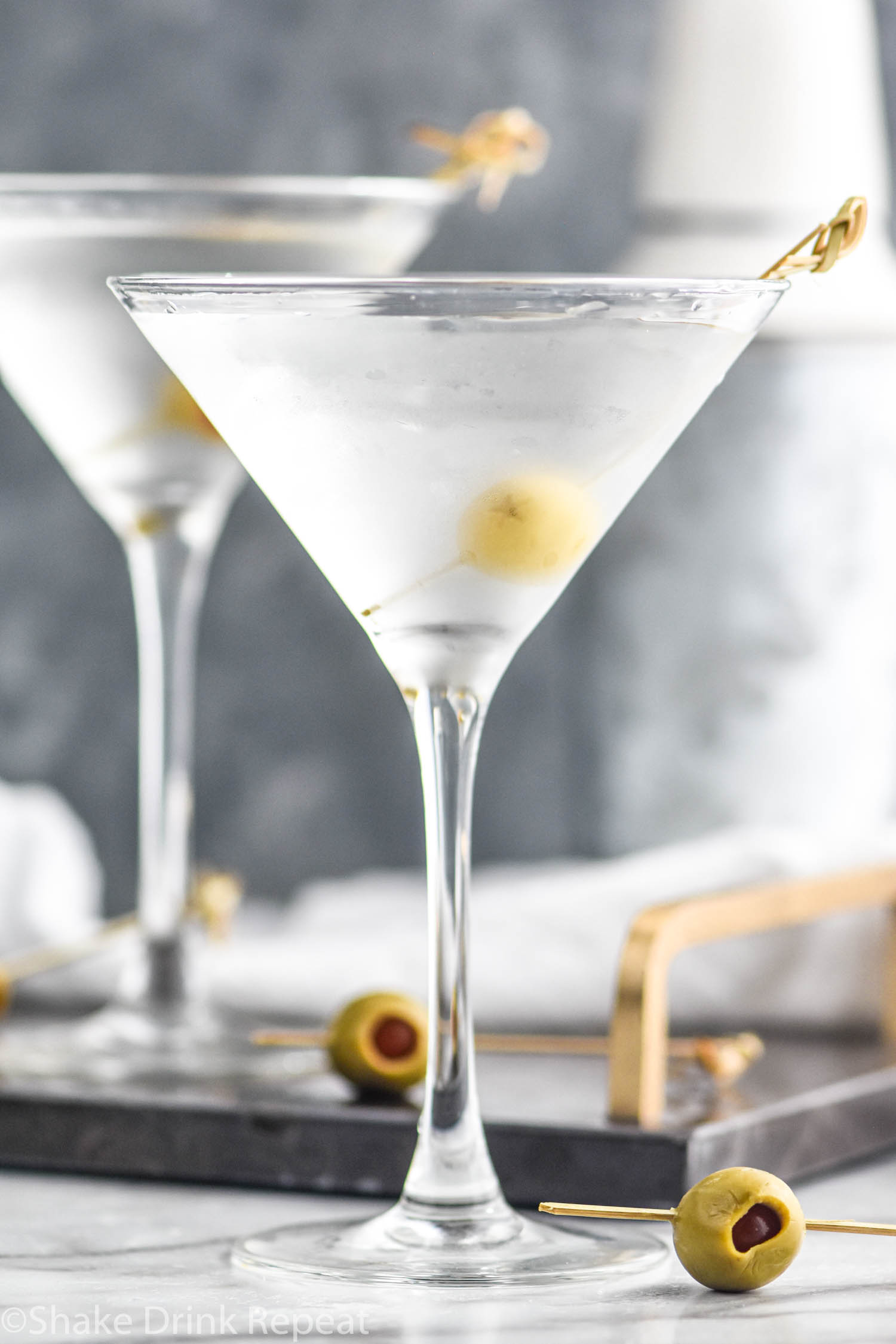 two glasses of vodka martini with olive garnish