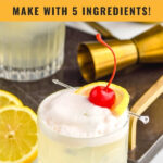 glass of vodka sour with frothy egg white and lemon slice and cherry garnish