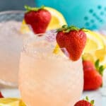 two glasses of vodka strawberry lemonade with ice, fresh strawberries, and lemon slices