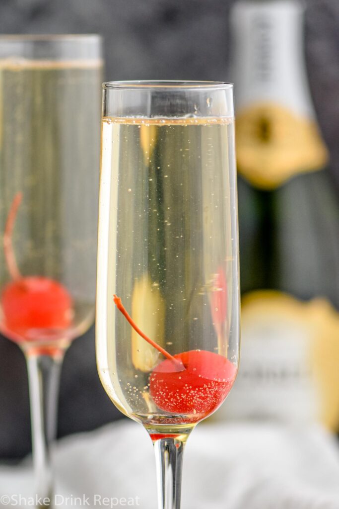 two glasses of French 76 with cherry garnish