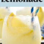 Glass of Frozen Lemonade with straws and garnished with a slice of lemon